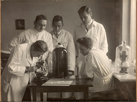 BILD: Laborszene 1929 (links im Bild, am Mikroskop, findet sich Rhoda
                        Erdmann, Mitbegründerin der experimentellen Zellbiologie in Deutschland.